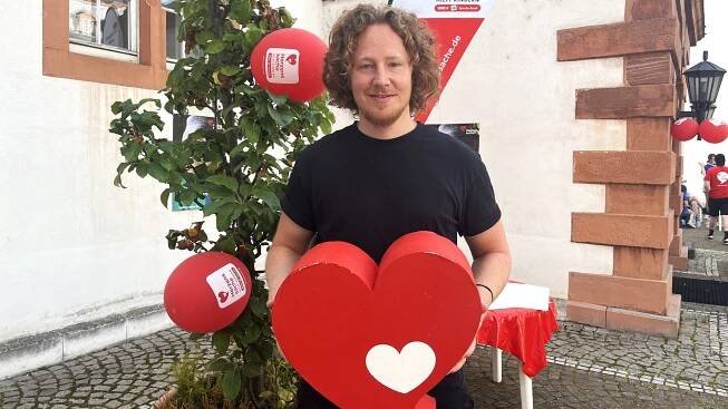 Michael Schulte hält ein Herzenssache-Herz in seiner Hand (Foto: Herzenssache)