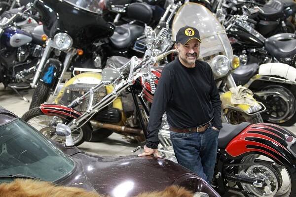 Frank Fritz, star of American Pickers, standing in his garage amongst his motorcycle collection.