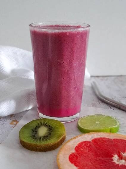 grapefruit kiwi lime smoothie with reusable straw on white background
