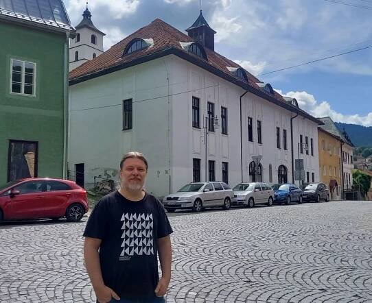 Historik Daniel Haas Kianička. V pozadí bývalá hasičská zbrojnica v Kremnici, budovu podľa najnovšieho výskumu navrhol Ladislav Hudec.