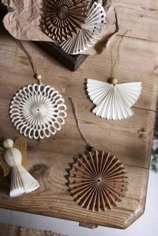 several decorative items are hanging on a wooden board with string and angel figurines
