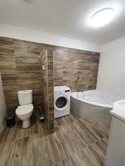 a bathroom with a toilet and a tub and a washing machine at Apartmány Nová duha Vavřinec in Vavřinec +37 photos