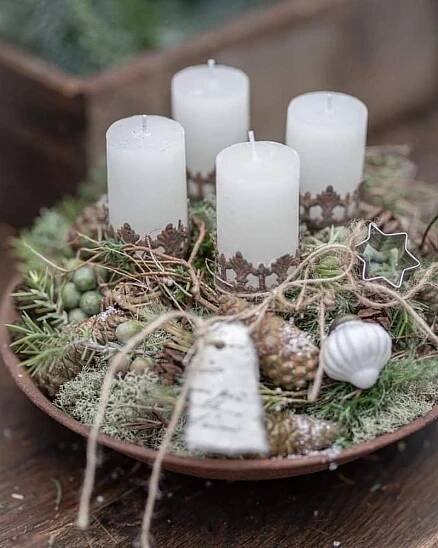 Weihnachtsdeko mit Kerzen, Moos und Tannenzapfen