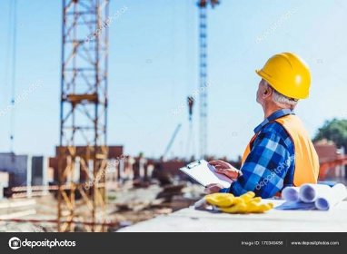 Stáhnout - Tvůrce v reflexní vestě a přilba stojící na staveništi s deskami v rukou — Stock obrázek