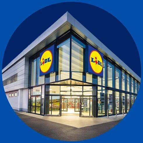 Ein modernes Lidl-Geschäft mit großen Glasfenstern und zwei leuchtenden Lidl-Logos.