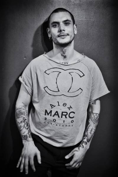 Giovane uomo con tatuaggi e maglietta t-shirt, ritratto in bianco e nero a Milano. Fotografo ritrattista professionista.