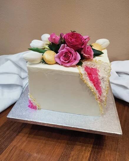 a white cake with pink and yellow flowers on top