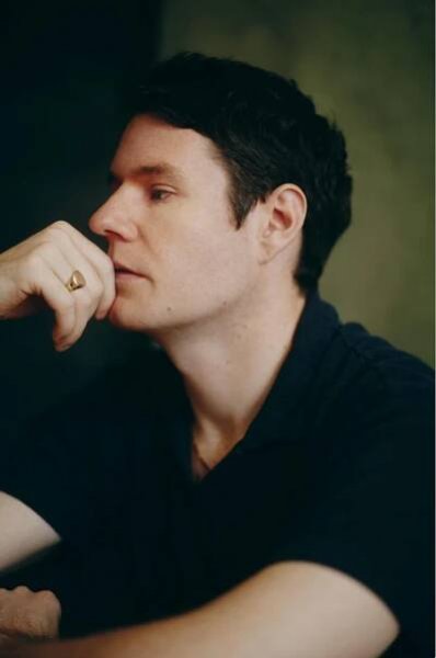 a person with a hand on their chin wearing a ring in a contemplative pose