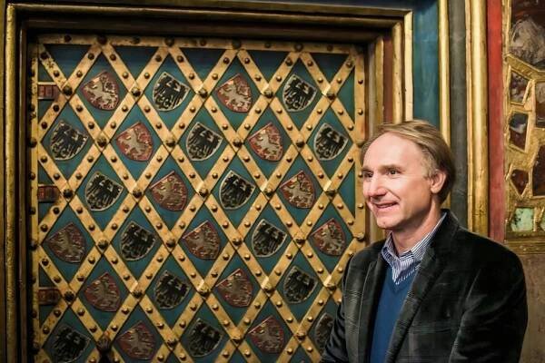Dan Brown u tajuplných pražských dveří, za nimiž se nacházejí korunovační klenoty.