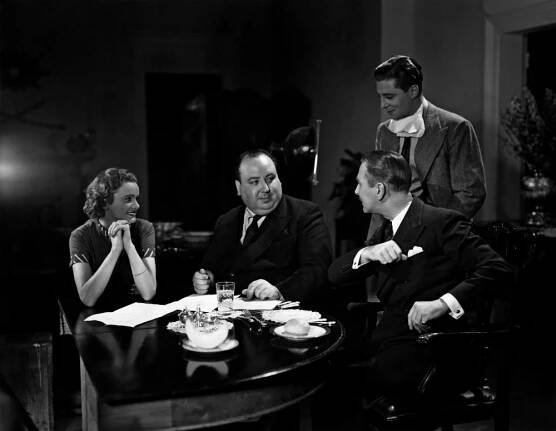 YOUNG AND INNOCENT, seated from left: Nova Pilbeam, director Alfred Hitchcock, Percy Marmont, Derrick De Marney (standing) on set, 1937