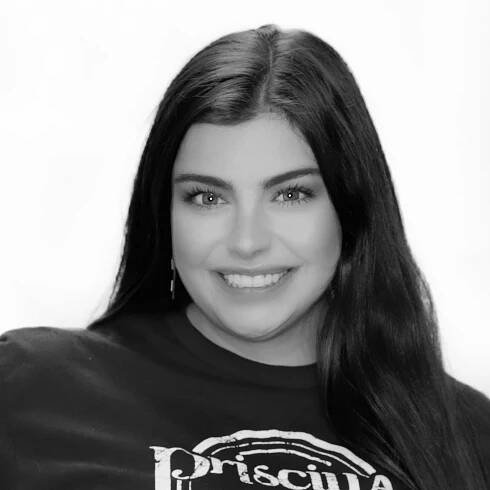 A black and white photo of a woman wearing a priscilla shirt
