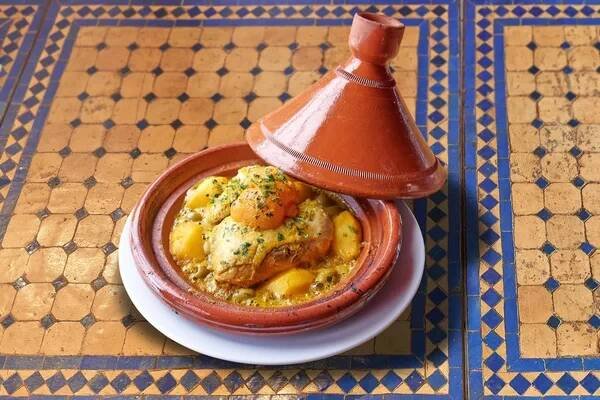 Marocké kuřecí tajine na barevném mozaikovém stole — Stock obrázek