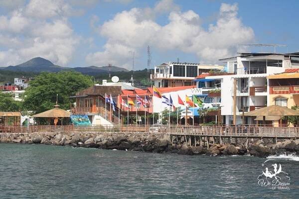 Colorful flags line the waterfront of Puerto Baquerizo Moreno in San Cristobal Galapagos seen from a boat.