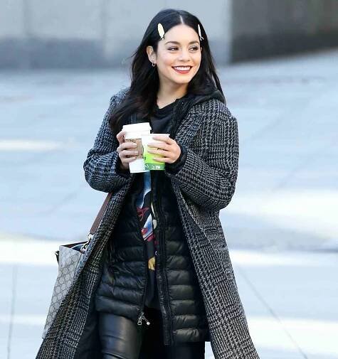 Actress Vanessa Hudgens walks to set with two cups of coffee filming 'Second Act' in New York City, New York.