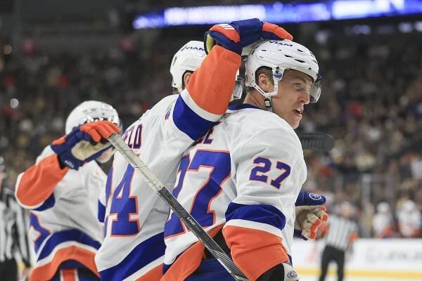 New York Islanders defenseman Scott Mayfield celebrating with left wing Anders Lee after scoring a goal against the Vegas Golden Knights during an NHL game