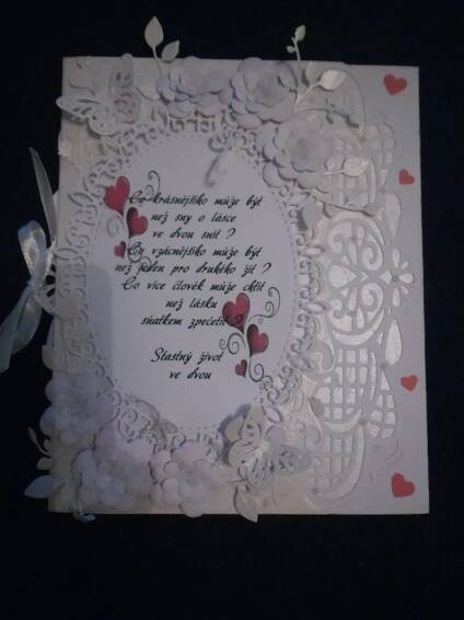 a white card with red hearts and a poem written on the front in cursive writing
