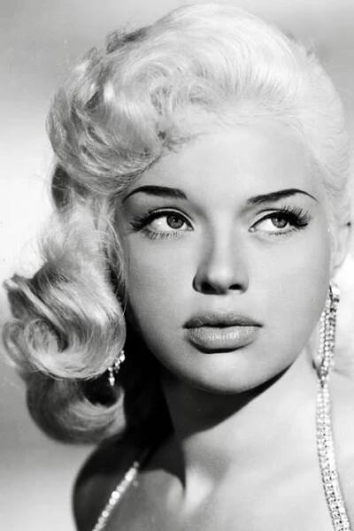an old black and white photo of a woman with blonde hair, wearing pearls on her necklace