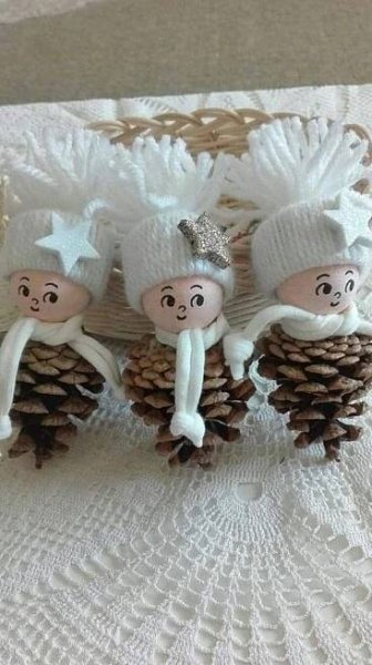 three small pine cones with white knitted hats on them and one is holding two people