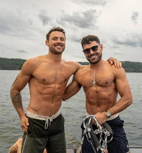 Zac Efron and his brother shirtless on a boat.