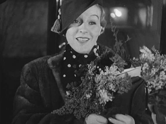Stillbild ur journalfilmen Veckorevy 1935-01-07 som visar skådespelerskan Tutta Rolf som håller i en blombukett.