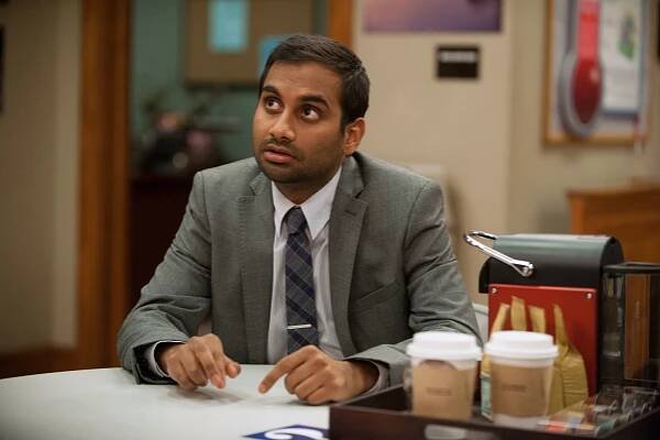 Tom sitting at a table in "Parks and Recreation"