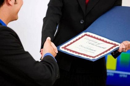 Woman handing a man a certificate