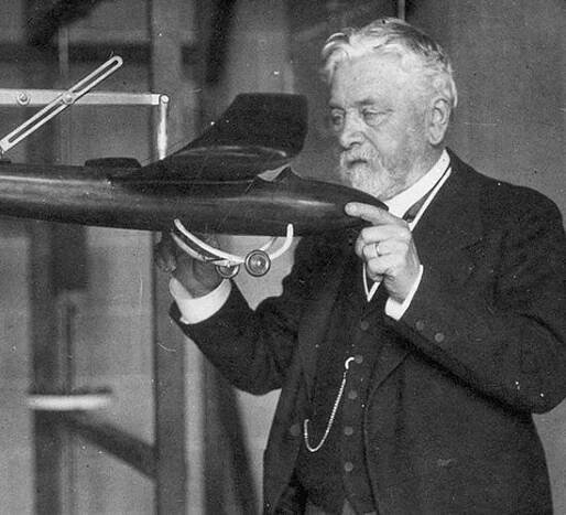 Gustave Eiffel in his laboratory holding a mock-up of a plane designed by Victor Tatin