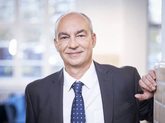 Sven Haberecht, Geschäftsführer Grün Berlin Service, lehnt sich an einen Pfeiler und trägt weißes Hemd, blaue Krawatte und dunkelblaues Sakko