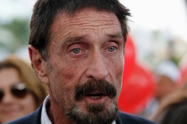 Computer software pioneer McAfee speaks with reporters outside his hotel in Miami Beach