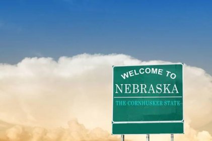 Nebraska state sign under a blue sky.