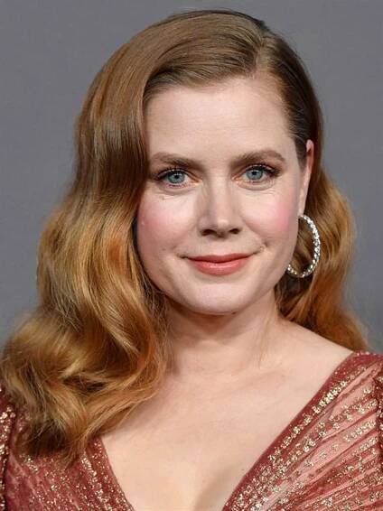 Amy Adams, attractive young woman with long wavy red hair and blue eyes, wearing low-cut red top and hoop earrings.