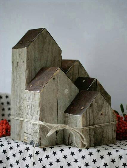 two wooden houses sitting on top of a black and white table cloth next to berries