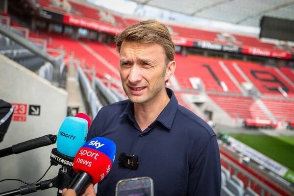 Simon Rolfes giving a press statement at a stadium.