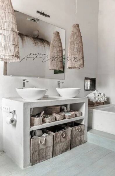 a white bathroom with two sinks and baskets under the mirror on the wall next to it