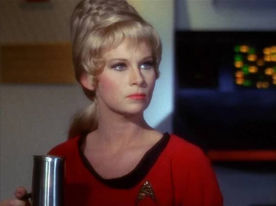 Janice Rand holding a futuristic mug of coffee