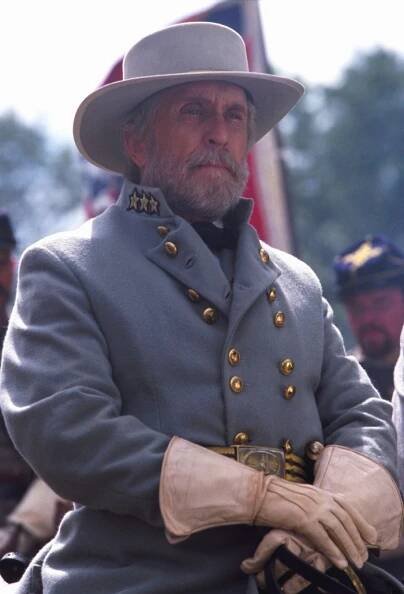 Robert Duvall in a costume with gloves and a hat