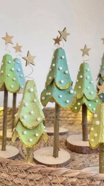 small christmas trees made out of cookies on wooden sticks with stars and pearls hanging from them