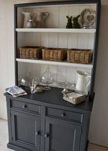 a black china cabinet with wicker baskets on it's top and bottom shelf