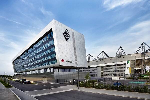 Außenansicht vom Hotel Mit dem Borussia Logo. Im Hintergrund steht das Stadion BORUSSIA-PARK.