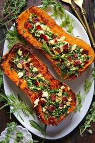 Stuffed Butternut Squash with Feta Cheese, Spinach, and Bacon - on a white platter.