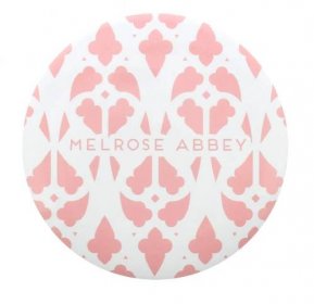 small round mirror featuring the words Melrose Abbey surrounded by a soft pink detail pattern 