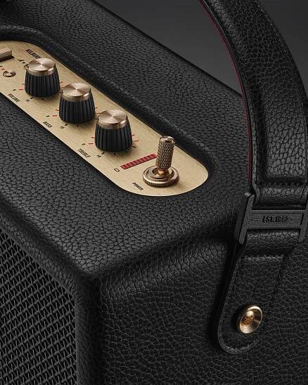 Close-up of the Marshall Kilburn III Black and Brass, featuring a black textured design, metal control knobs, a toggle switch, and a leather handle for easy portability.