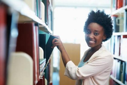 A young woman selecting some books in the library