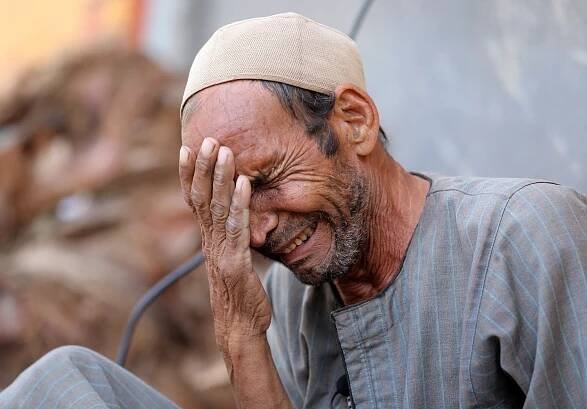 Hassan El Salheen, weeps after burying the repatriated body of his son, Aly, who died along with his three cousins in Libya after Storm Daniel hit the country, at Al Sharief village in Bani Swief province