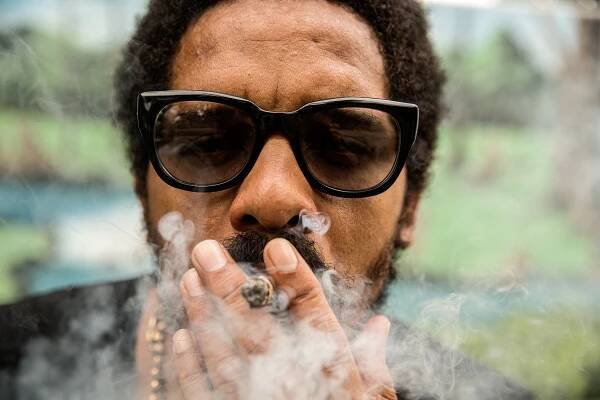 A photo of Rohan Marely, the Son of legend Bob Marley and owner of Marley Coffee, smoking a spliff, joint at the Bob Marley Museum in Kingston, Jamaica. Lifestyle photographer 
industrial photographer 
advertising photographer