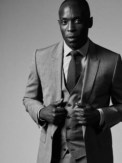 This image may contain Suit Coat Clothing Overcoat Apparel Tie Accessories Accessory Human Person Man and Face