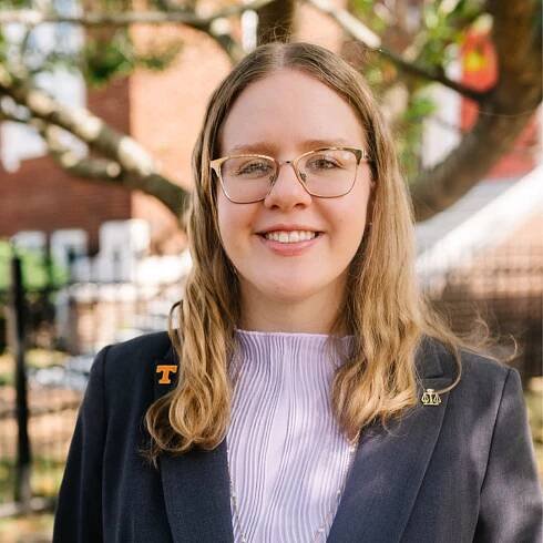 Attorney Deborah Moore standing outside of building in front of a tree with professional attire.