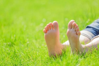 Ženské bosé nohy na zelené trávě — Stock obrázek