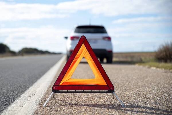 Problems car and a red triangle warning sign on the road