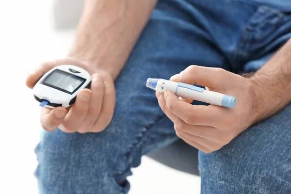 Diabetická muž, který držel digitální glukometr a lancety pen, closeup — Stock obrázek